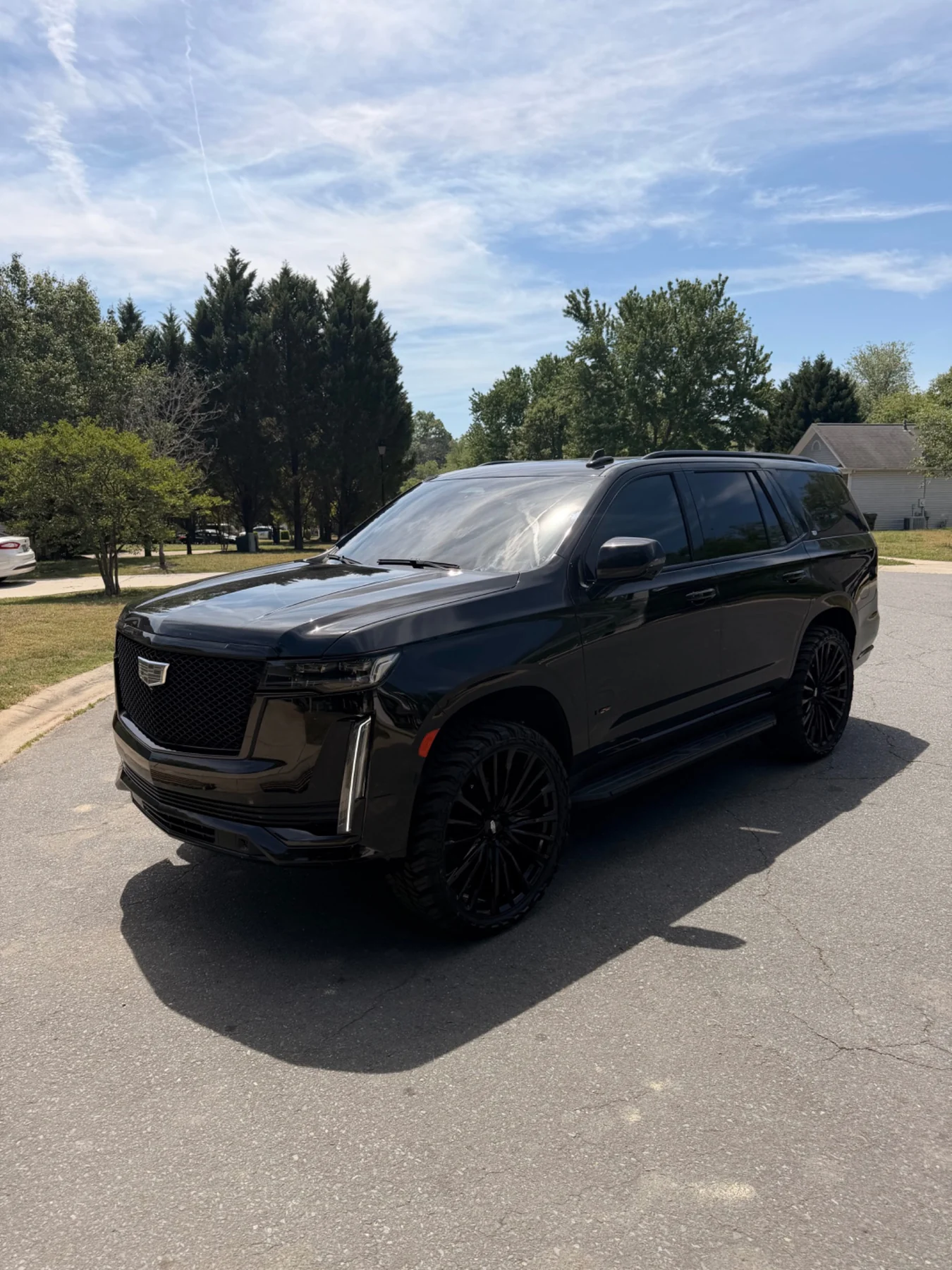 Black Cadillac Escalade with blackout wheels and dark window tint